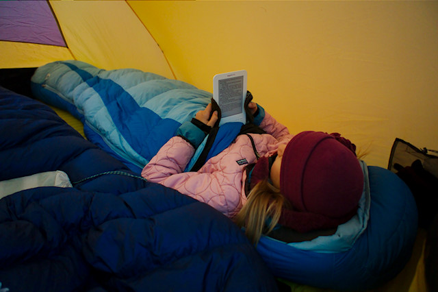 girl reading Kindle in tent