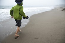 boy running barefoot on beach