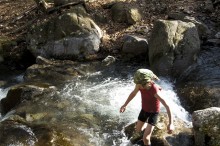 boy splashing in mountain stream