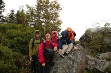 family on mountain summit in rain